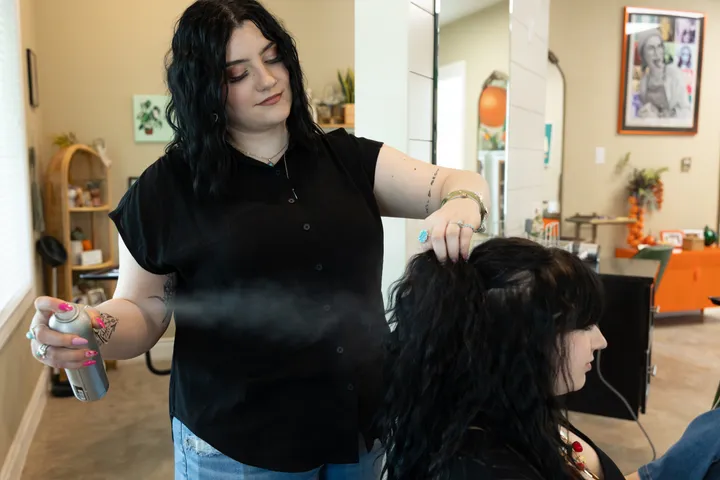 A stylist working with a guest’s short hair