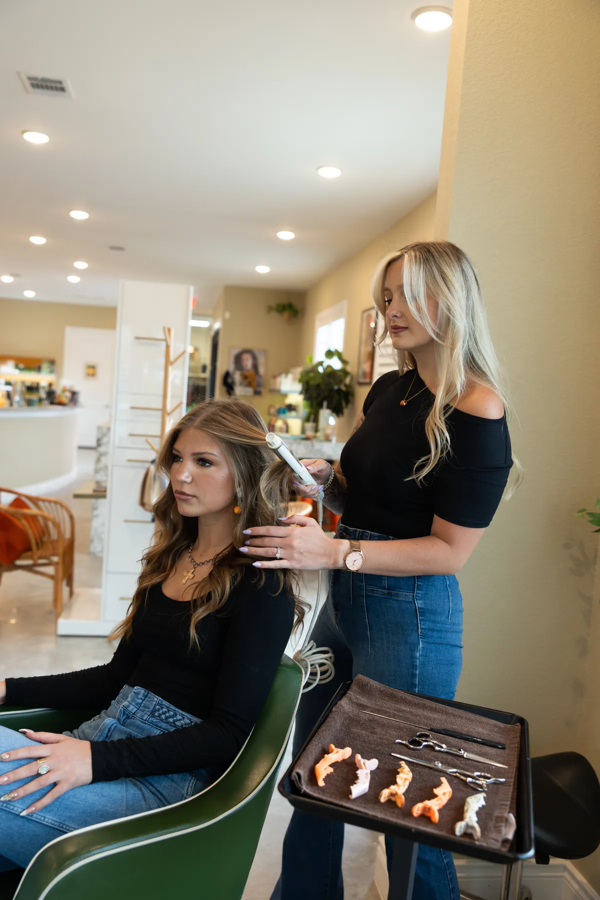 A stylist finishing soft curls for a guest at Hart Studios