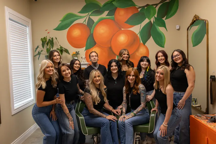 The Hart Studios team gathered by the orange mural
